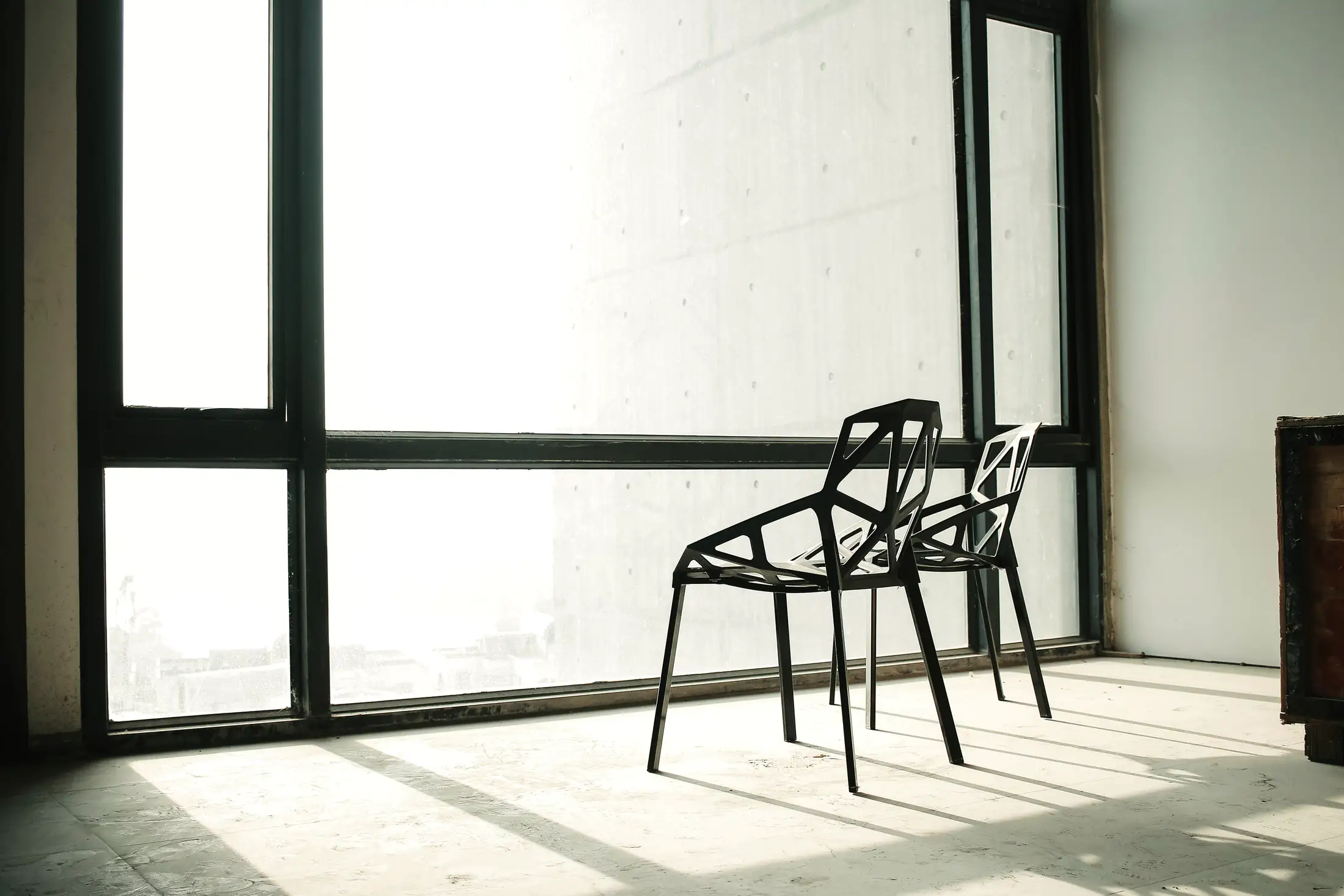 Empty chairs beside a tall office window